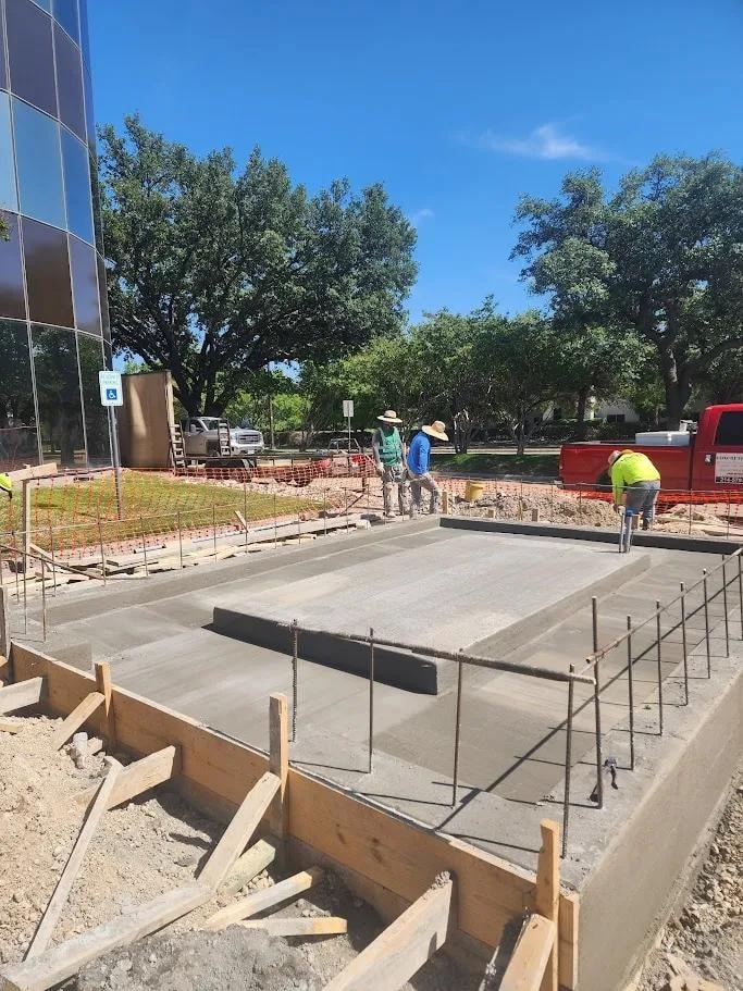 Crew pouring and finishing commercial concrete slab