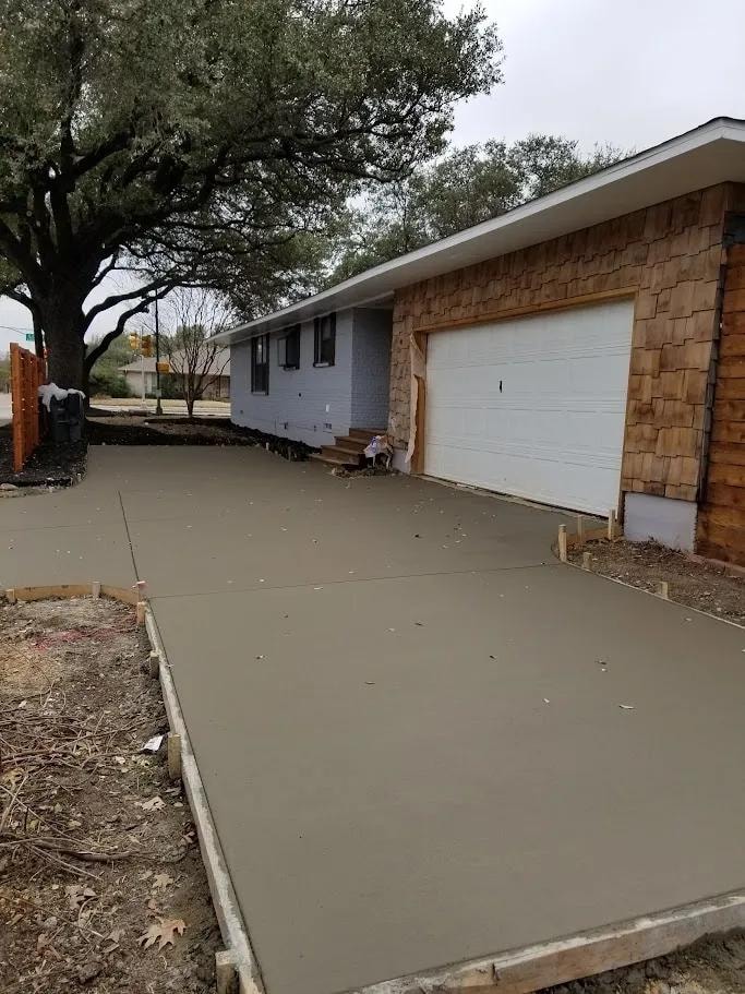 After: freshly poured concrete driveway at cedar siding home