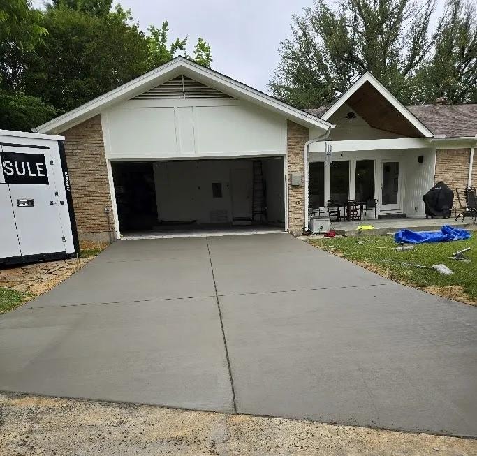 Freshly poured concrete driveway at stone and brick garage home